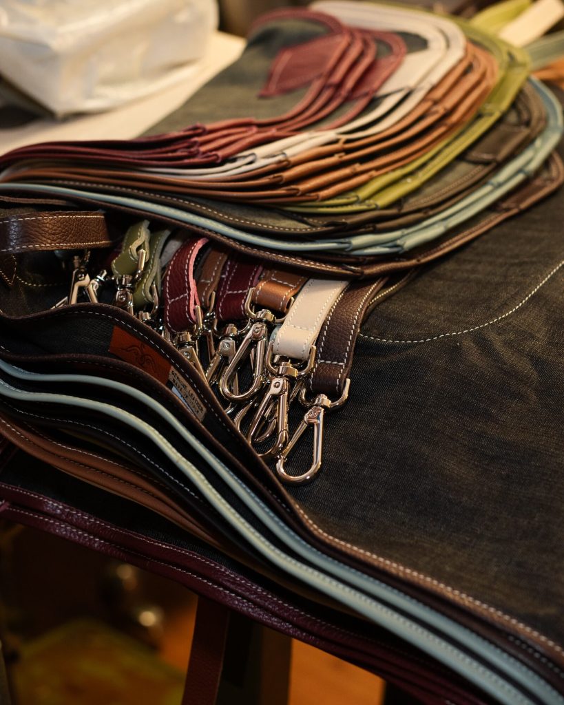 Handcrafted leather straps with metal snap hooks and denim aprons by Bojola